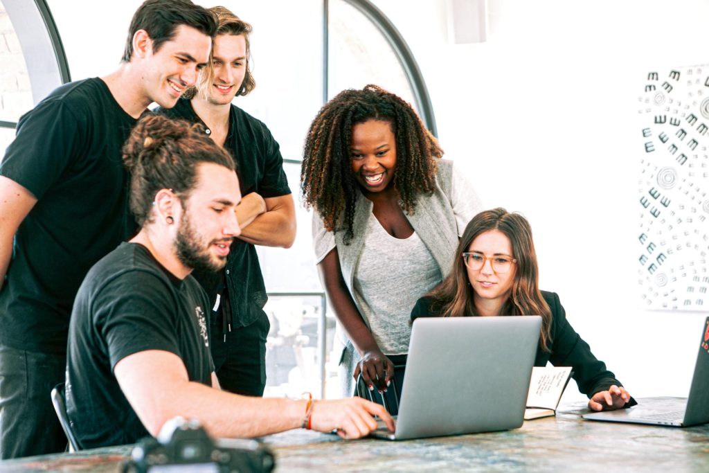 a group of people looking at a laptop