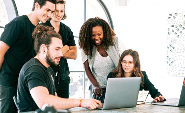 a group of people looking at a laptop